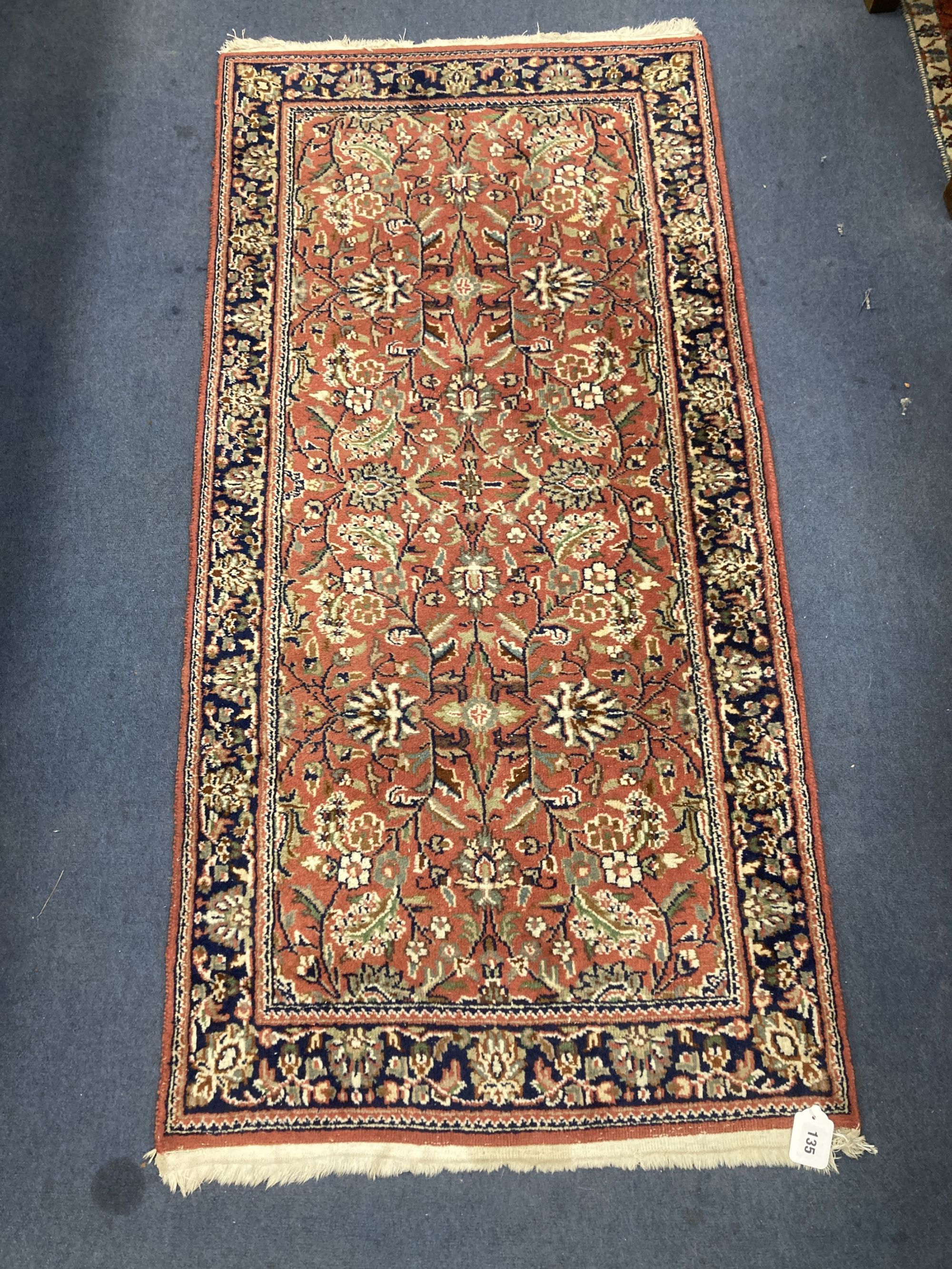 A Persian burgundy red ground rug, 146 x 69cm
